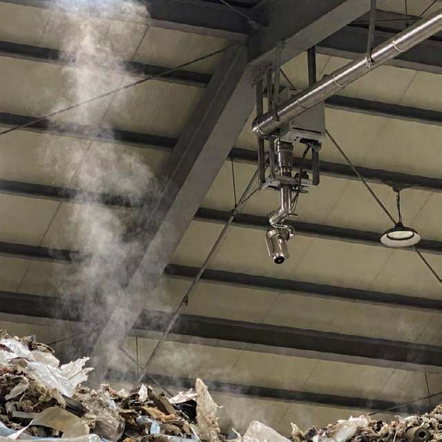 Water cannon mounted overhead above a waste pile in a bunker